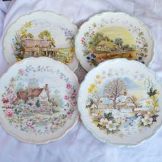 four plates with pictures of houses and flowers on them