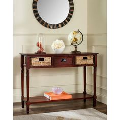 a console table with two baskets under it and a round mirror above it on the wall