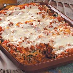 a casserole dish with meat, cheese and sauce in it on a table