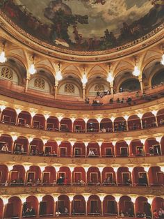 an auditorium filled with lots of red seats