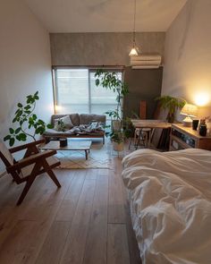 a living room filled with furniture next to a window covered in white sheets and blankets