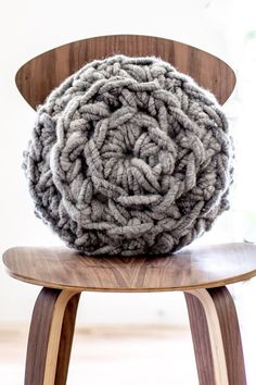 a large chunky blanket sitting on top of a wooden chair