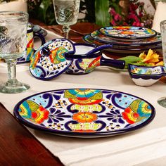 the table is set with colorful dishes and glasses