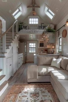 a living room filled with furniture next to a stair case in a loft style home