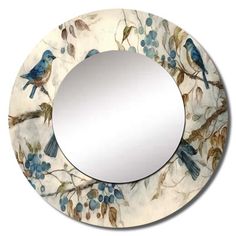 a round mirror with birds and berries on it