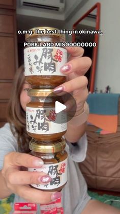 a woman holding three jars of food in front of her face and the caption reads,