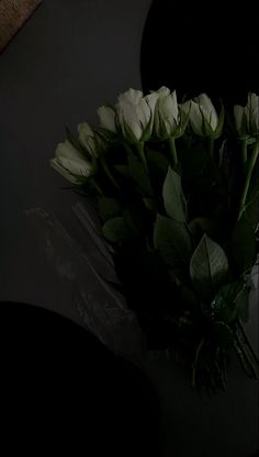 a bouquet of white roses sitting on top of a table