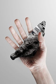 a hand holding a piece of black and white material in it's left palm