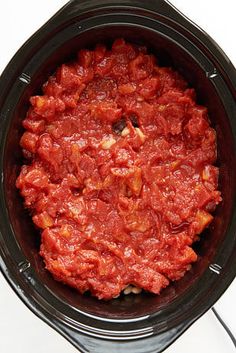 a crock pot filled with meat sitting on top of a table