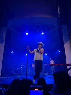 a woman standing on top of a stage holding a microphone