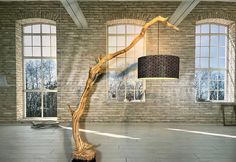 an artistic sculpture in the middle of a room with large windows and a lamp hanging from it's ceiling