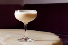 a glass filled with liquid sitting on top of a table