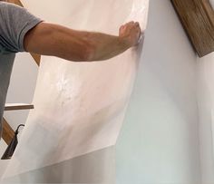 a man is painting the wall with white paint