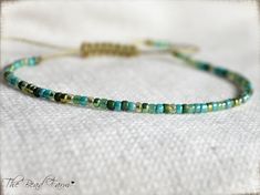 "Dainty Adjustable Hippie Yoga Style Anklet -or- Bracelet with sliding closure. This one-size-fits-all piece features small 8/0 seed beads in a blend of beachy blues and greens.  So summery!  All beads are strung on nylon cord in color- Khaki. The tail ends of the cord are securely knotted then \"fringed\" to give a little extra boho style. Stacks well with other jewelry pieces or can stand alone.   Style: ANKLET: opens fully to a 13\" circumference which will slip over the widest part of the foot for most people. After slipping over your foot, pull the tail ends to the desired fit around your ankle. If you feel like you may need a larger circumference, use the reference photo on how to measure the widest part of your foot. If your measurement is larger than 13\", please leave me a note at Handmade String Bracelets, Farm Jewelry, Blue Anklet, Handmade Anklets, Boho Wrap Bracelet, Anklets Boho, Yoga Style, Blues And Greens, Yoga Bracelet