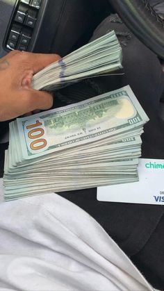 a person holding cash in their hand while sitting in the back seat of a car