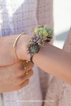 a close up of a person wearing a bracelet with flowers on it