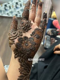 a woman's hand with henna tattoos on it