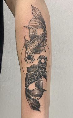 a black and white photo of a fish tattoo on the arm