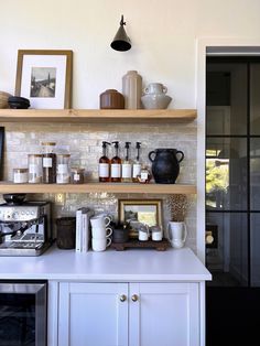 a kitchen with shelves filled with coffee cups and mugs on top of it's counter