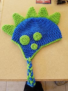 a crocheted blue and green hat sitting on top of a table