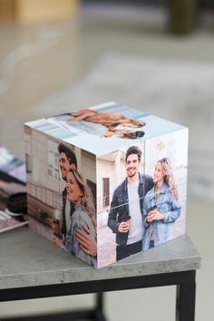 a photo cube sitting on top of a table next to a magazine and coffee cup