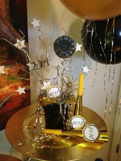 a table topped with balloons and confetti next to a clock on top of it