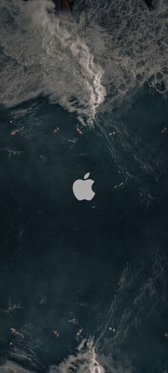 an apple logo is seen in the middle of some dark blue water with waves around it