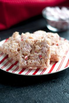 two pieces of food on a plate with red and white striped paper next to it