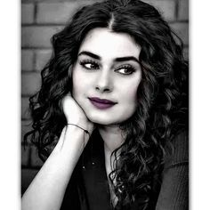 a black and white photo of a woman with long curly hair, wearing a sweater