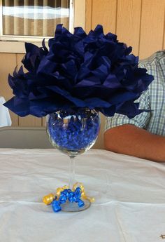 a blue flower in a wine glass on a table