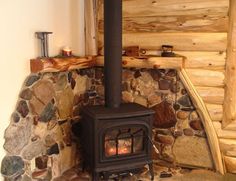 a wood burning stove sitting inside of a log cabin