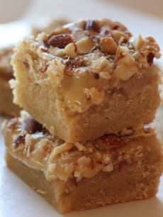 three pieces of cake sitting on top of a white plate with nuts and pecans