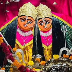 two masks are sitting on display in front of flowers