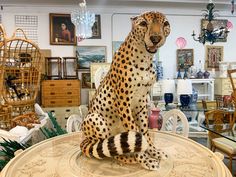 a cheetah statue sitting on top of a table in a room filled with furniture