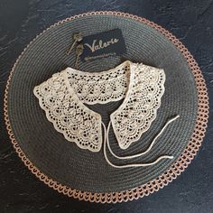 a crocheted doily on a plate with a name tag attached to it