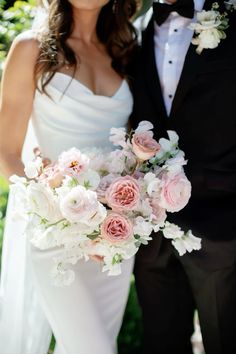 the bride and groom are posing for a photo with flowers in their bouquets on their wedding day