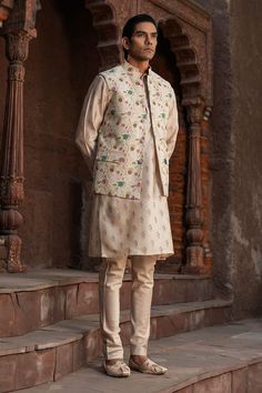 Ivory base kurta with mughal floral prints. Paired with a churidar. Comes along with a bundi with mughal prints. - Aza Fashions Off White Naqshi Nehru Jacket For Eid, Off White Nehru Jacket With Naqshi For Eid, Traditional Off White Nehru Jacket With Naqshi, Cream Nehru Jacket With Naqshi For Eid, Cream Nehru Jacket With Dabka And Straight Kurta Shape, Cream Nehru Jacket With Dabka, Straight Kurta Style, Cream Nehru Jacket With Dabka On Straight Kurta, Cream Nehru Jacket With Naqshi For Festivals, Festive Off White Nehru Jacket With Naqshi