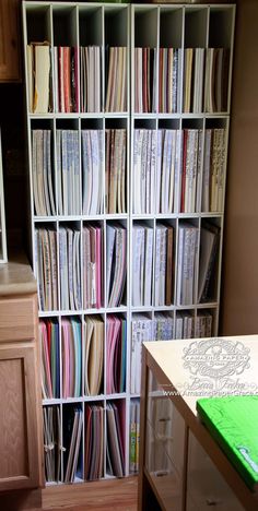 a bookcase filled with lots of books next to a wooden cabinet full of papers