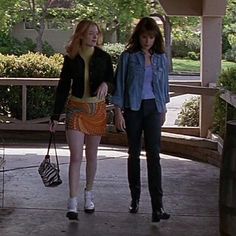 two young women walking down a sidewalk together