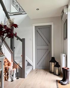 an entry way with a wooden floor and white walls, decorated with fall foliages