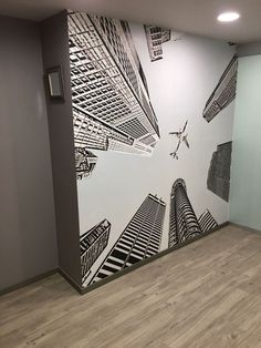 an office with a large mural on the wall and wood flooring in front of it