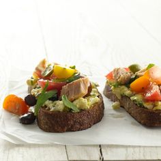 two pieces of bread topped with vegetables and meat