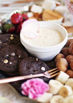 a plate full of cookies, doughnuts and other food items with strawberries on the side