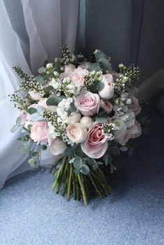 a bouquet of flowers sitting on top of a blue carpeted floor next to a window