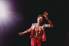 a man in red pants and tattoos on stage