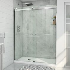 a white bathroom with a glass shower door