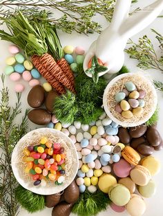 an arrangement of chocolate eggs, marshmallows, carrots and bunny ears