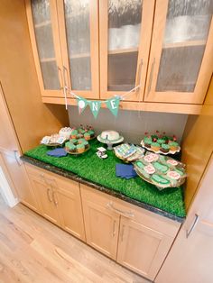 a kitchen counter topped with lots of cakes and cupcakes