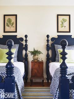 two twin beds in a bedroom with blue headboards and green pillows on the covers