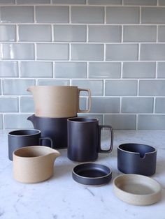 a table topped with lots of different types of cups and saucers on top of a white counter